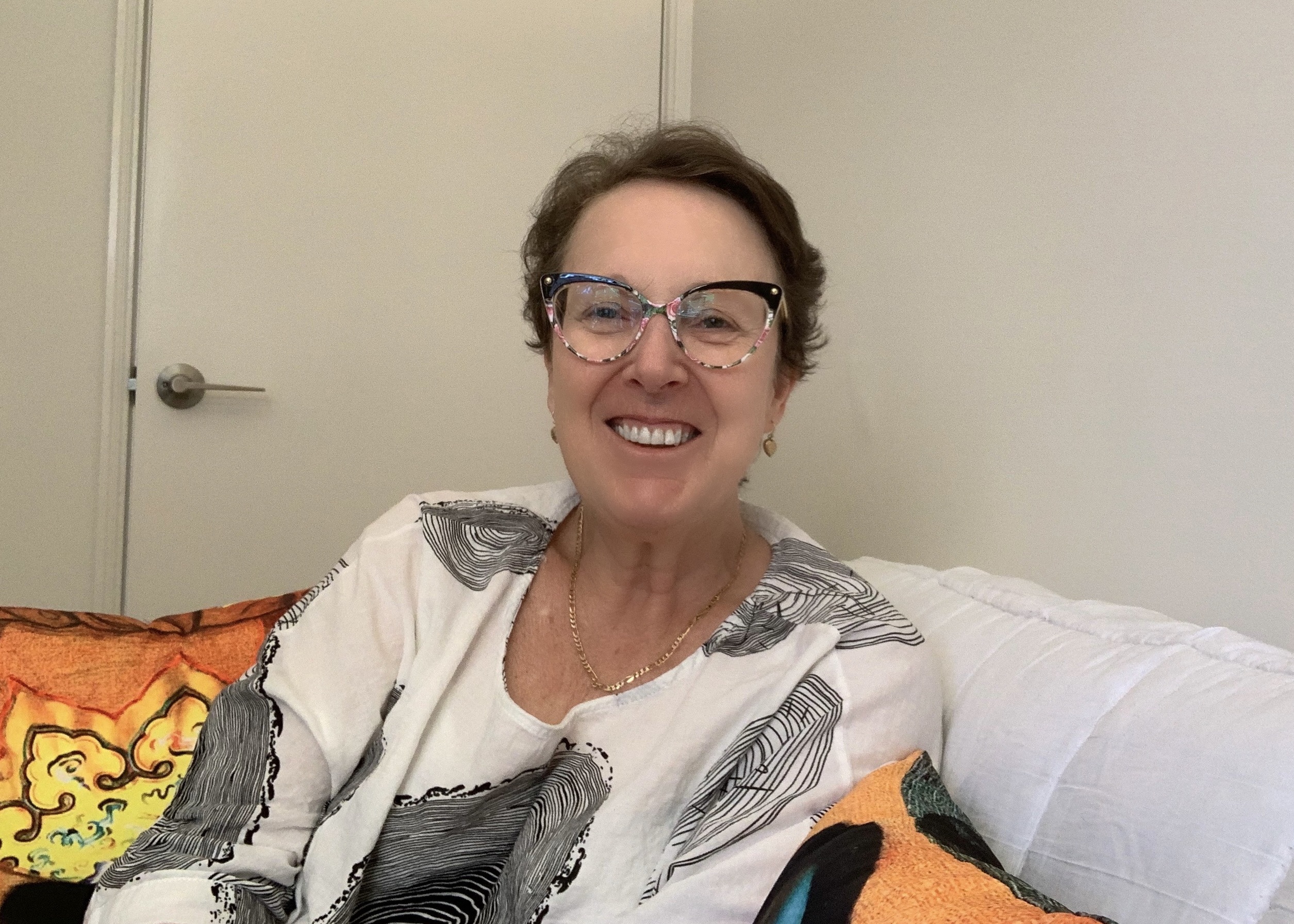 Sarah-Jane Smith smiling sitting in her studio at home